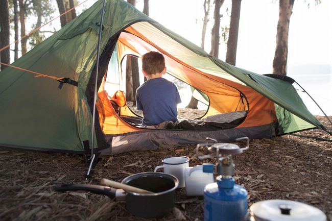 Young boy sitting alone in tent