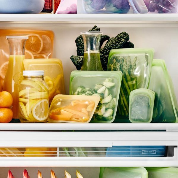 Colourful silicon bags full of fruit and vegetables in the fridge.